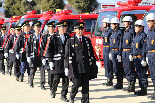 竜王小学校にて甲斐市消防団出初式で 副団長や市長の方たちが並んで歩いている写真